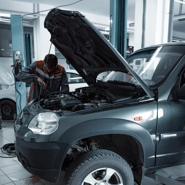 Mecânico examinando o motor de um carro na oficina