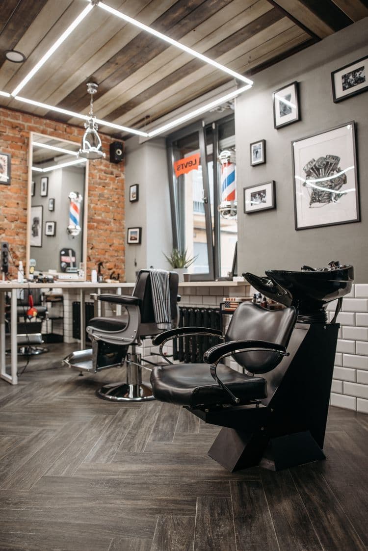 Interior de uma barbearia com cadeiras e bancada de trabalho